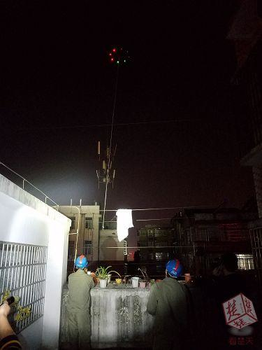 厉害啦！棉被被风吹到高压钱上，电工用无人机“钓”起
