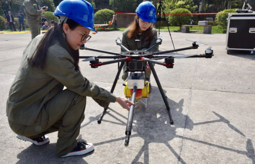 风筝缠在杆塔导线上 娘子军操控无人机喷火作业