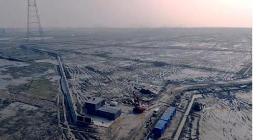 无人机拍摄特斯拉上海工厂：一片泥地、数个集装箱、简易办公室